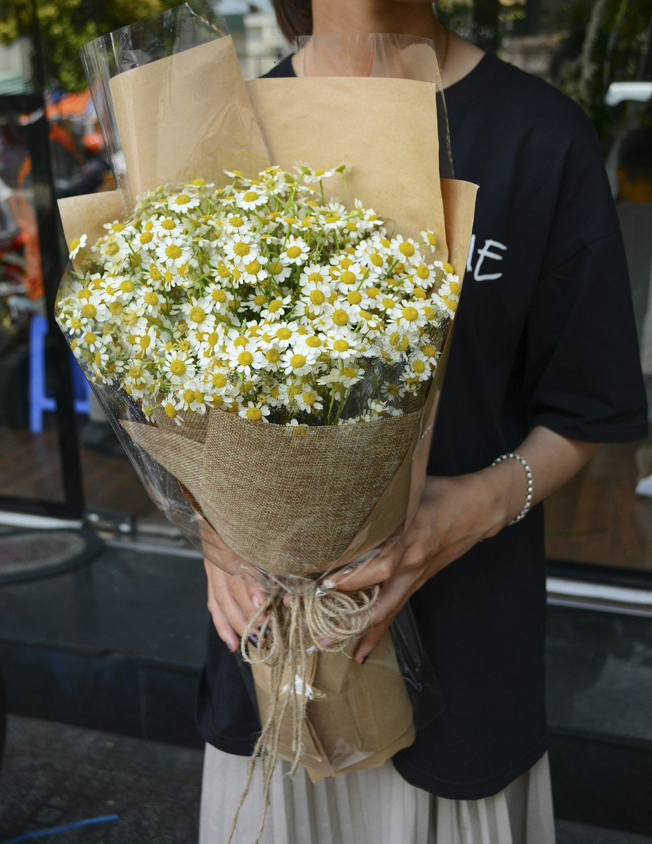 Client smiling with floral arrangement